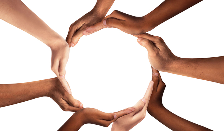 Conceptual symbol of multiracial human hands making a circle on white background with a copy space in the middle.