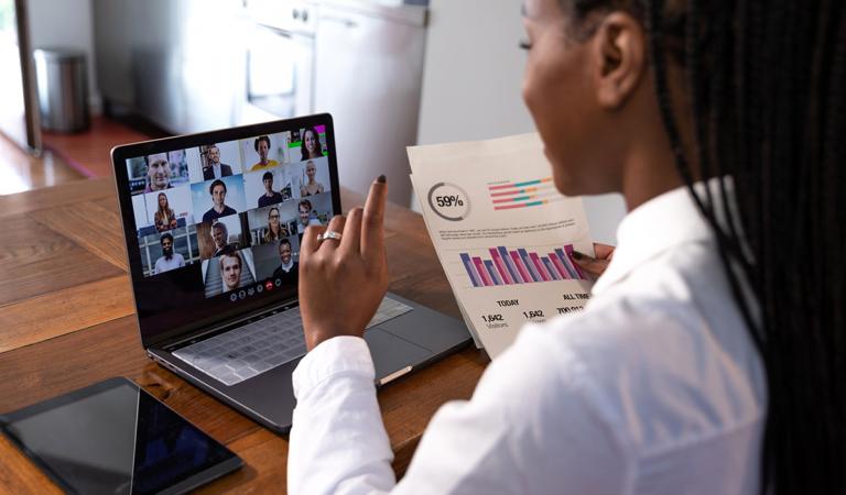 Mulher trabalhando em casa em um laptop, teletrabalhando com parceiros de negócios